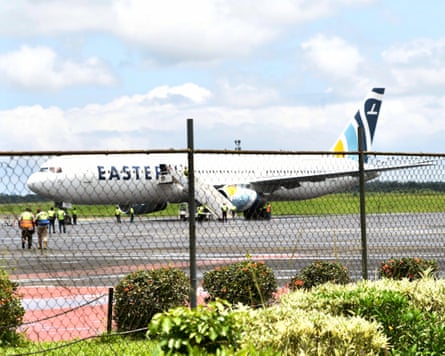 A plane on the tarmac and people disembarking