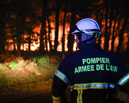A firefighter with the French air force looks on as a wildfire burns through the Landes forest in Luglon, south-west France.