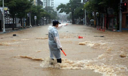A police officer controls a road covered with floodwaters following the torrential rain in Geoje.