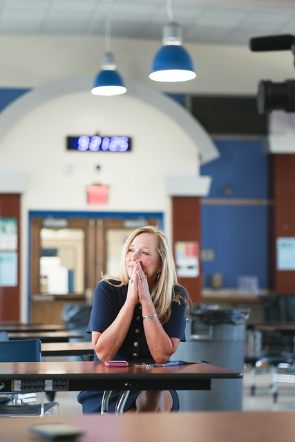 Ashley Powell is pictured sitting inside a cafeteria.