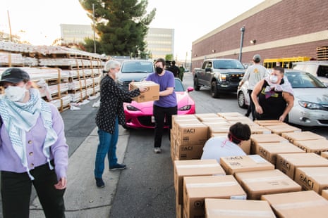 Volunteers distributing brown boxes full of masks