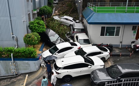 Vehicles lie piled up in Geoje, South Korea, on Monday after a landslide caused by heavy rains