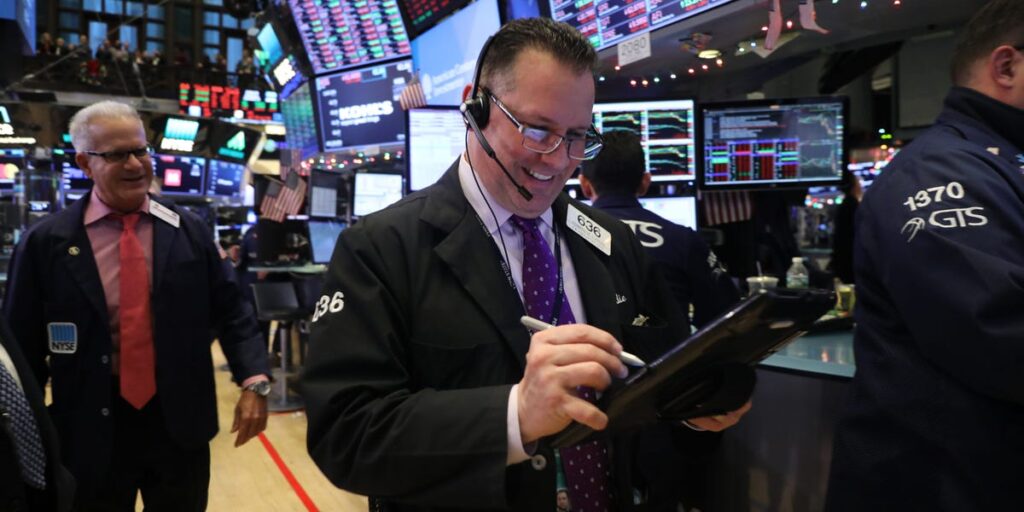 Dow surges to record close after fresh tech rally and a plunge in oil prices