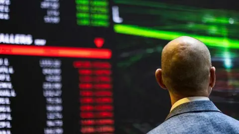 Getty Images A stock marker trader looks at a large screen