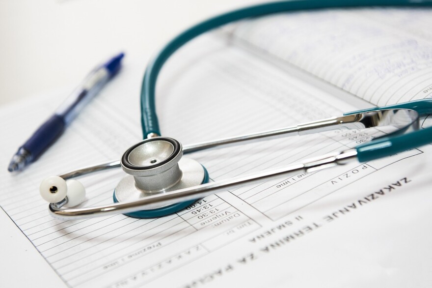 A stethoscope rests on a notebook of medical information.