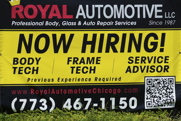 A now hiring sign is seen in front of an auto body shop in Chicago, June 25, 2026. (AP Photo/Nam Y. Huh, file)