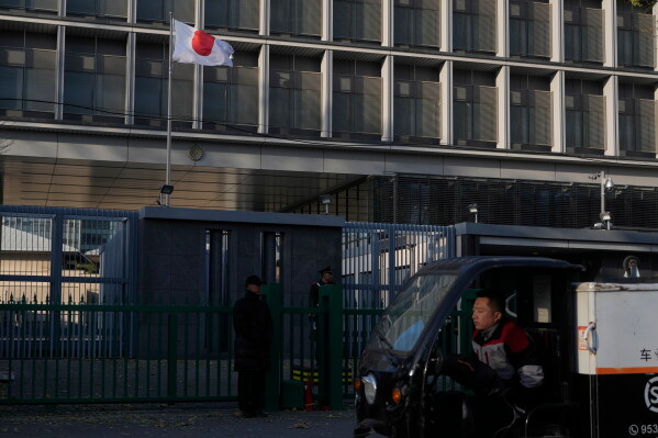 A delivery man drives past the Japanese Embassy in Beijing on Nov. 24, 2025. (AP Photo/Ng Han Guan)