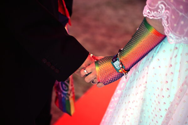 A couple exchange vows during a mass wedding ceremony in an inflatable chapel in Amsterdam, Netherlands, Thursday, Aug. 6, 2026, as part of Pride events celebrating 25 years since the Netherlands became the first country in the world to legalize same-sex marriage. (AP Photo/Mouneb Taim)