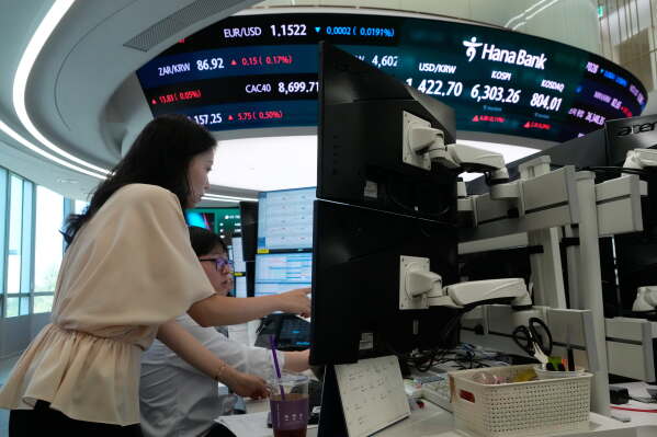 Currency traders watch monitors at the foreign exchange dealing room of the Hana Bank headquarters in Seoul, South Korea, Friday, Aug. 7, 2026. (AP Photo/Ahn Young-joon)