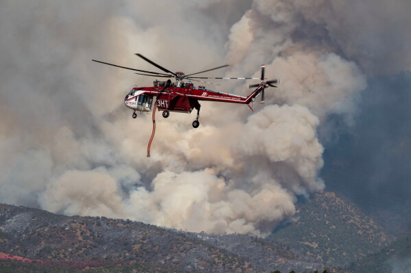 A Sikorsky Skycrane maneuvers into position to refill during efforts to fight the Widemouth 2 Fire east of Fillmore, Utah, on Tuesday, Aug. 4, 2026, before it crashed on Friday, Aug. 7. (Scott G Winterton/The Deseret News via AP)