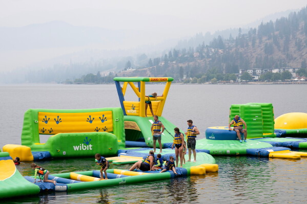 People play at the Peachland Water Park in Peachland, British Columbia, Canada, on Saturday, Aug. 8, 2026. (Gary Nylander/The Canadian Press via AP)