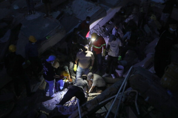 People search through the rubble after an earthquake struck Cali, Colombia, Monday, Aug. 10, 2026. (AP Photo/Santiago Saldarriaga)