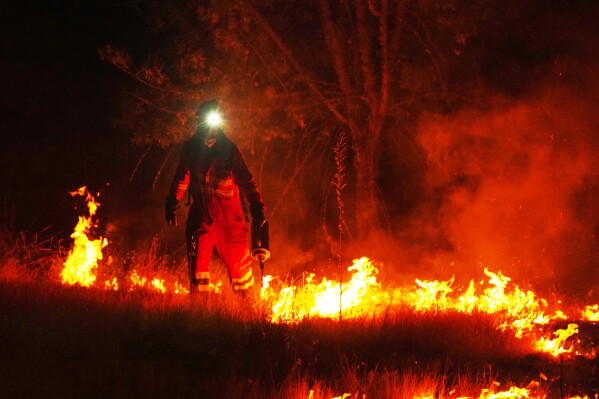 Firefighters use controlled burning to halt a wildfire that continues to spread near Cebreros, Ávila province, Spain, Tuesday, July 28, 2026. (AP Photo/Manu Fernandez)