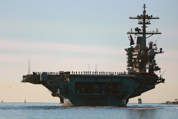 Sailors and marines line the deck of aircraft carrier USS Abraham Lincoln (CVN-72) as it deploys from San Diego,, Jan. 3, 2021. (K.C. Alfred/The San Diego Union-Tribune via AP, File)