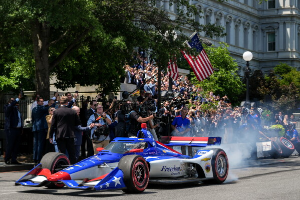 IndyCar Series driver David Malukas drives a race car down West Executive Drive during an event with President Donald Trump to promote the upcoming Freedom 250 Grand Prix auto race, Monday, July 13, 2026, at the White House in Washington. (AP Photo/Julia Demaree Nikhinson)