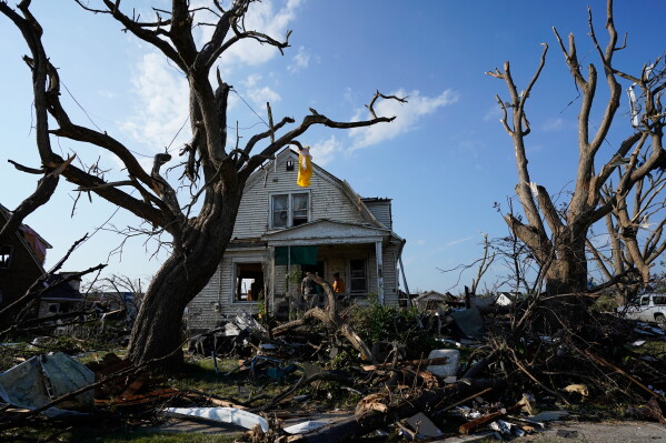 Debris is seen in front of a damaged house after a tornado struck Monday, July 27, 2026, in Menasha, Wis. (AP Photo/Kayla Wolf)