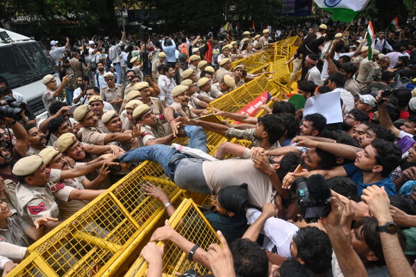 Supporters of the Cockroach Janta Party scuffle with police as they attempt to march toward India's Parliament, demanding the resignation of the education minister, in New Delhi, Monday, July 20, 2026. (AP Photo/Vipin)