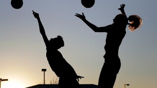 FILE - Friends practice volleyball at a local park in Gilbert, Ariz., March 15, 2020.