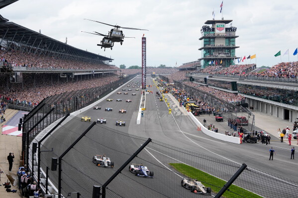 Helicopters fly over the field on the parade lap before the Indianapolis 500 auto race in Indianapolis, May 24, 2026. (AP Photo/Michael Conroy, File)