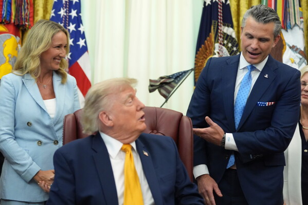 Defense Secretary Pete Hegseth, from right, speaks as President Donald Trump and Jennifer Hegseth listen during a meeting about military families, in the Oval Office of the White House, Monday, Aug. 3, 2026, in Washington. (AP Photo/Alex Brandon)