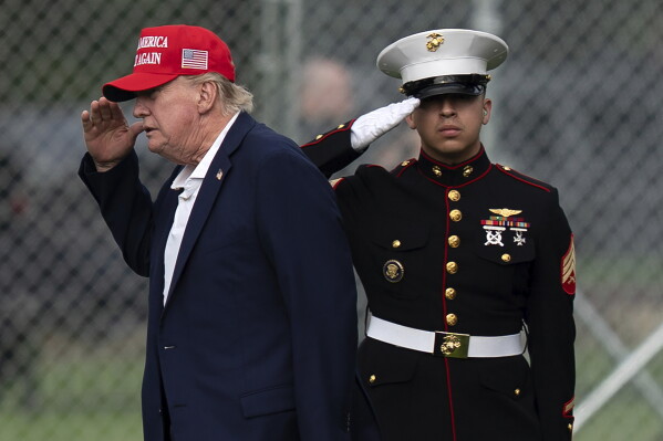 President Donald Trump returns a salute as he walks from Marine One to his limousine upon his arrival at the Ellipse just outside of the White House, Sunday, Aug. 16, 2026, in Washington. (AP Photo/Jose Luis Magana)