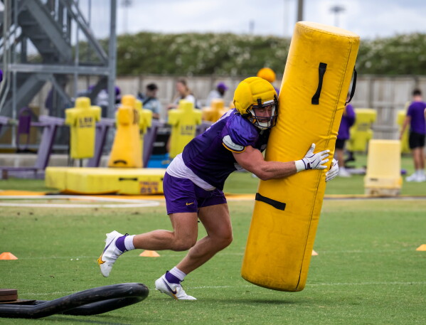 LSU defensive end Dylan Carpenter drives into a tackling dummy during an NCAA college football practice Monday, Aug. 10, 2026, in Baton Rouge, La. (Michael Johnson/The Advocate via AP)