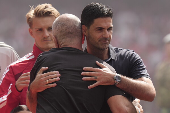 Arsenal's manager Mikel Arteta, right, hugs with Manchester City's head coach Enzo Maresca prior to the FA Community Shield final soccer match between Arsenal and Manchester City in Cardiff, Wales, Sunday, Aug.16, 2026. (AP Photo/Alastair Grant)