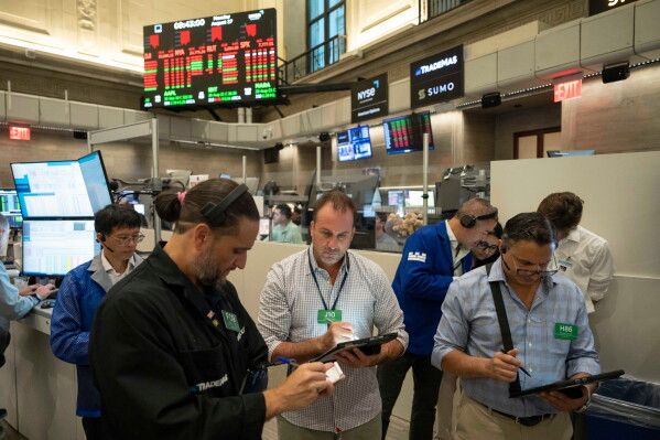 Options traders Chris Dattolo, Scott Frinzi, and Ravi Bhandari, left to right, work on the floor of the New York Stock Exchange, Monday, Aug. 17, 2026, in New York. (AP Photo/Yuki Iwamura)