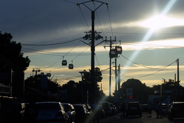 Cable cars cut across the skyline during testing in Antananarivo, Madagascar, Sunday, April 6, 2025. (AP Photo/Alexander Joe)