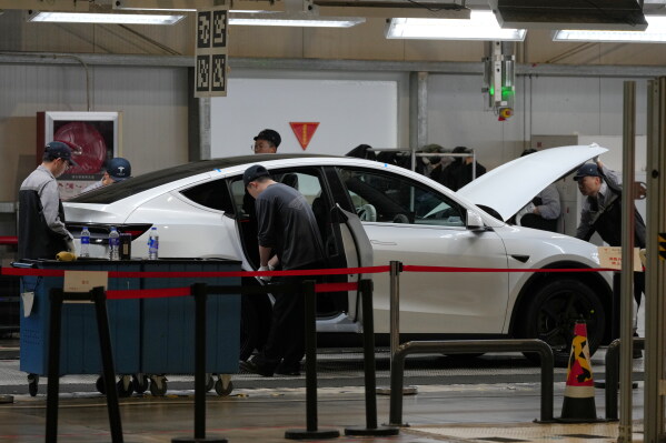 People work on the Tesla Model Y production line at the Tesla Gigafactory assembly plant during a media organized tour, in Shanghai, China, Tuesday, April 14, 2026. (AP Photo/Andy Wong, File)