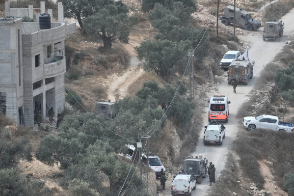 Israeli soldiers secure a building under construction as ambulances evacuate injured Palestinians following an attack by Israeli settlers in the occupied West Bank village of Qusra, Saturday, Aug. 29, 2026. (AP Photo/Majdi Mohammed)