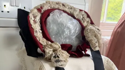 A red bonnet with cream lace details