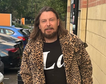 Matt Arnold, who has long brown hair, wearing a leopard print jacket