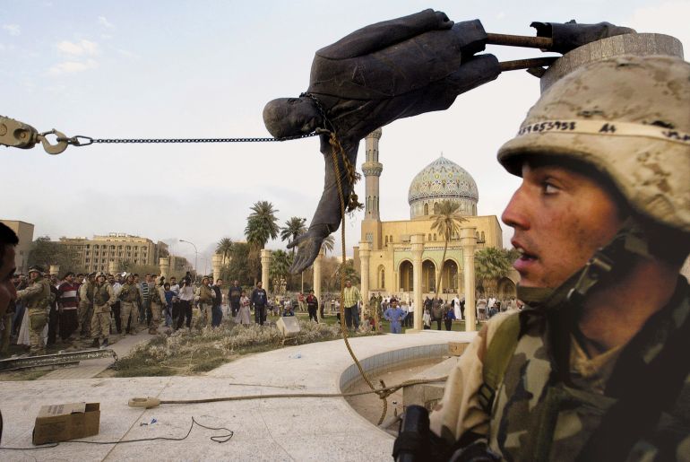 Iraqi civilians and US soldiers pull down a statue of former leader Saddam Hussein in downtown Baghdad, Iraq in this April 9, 2003 photo