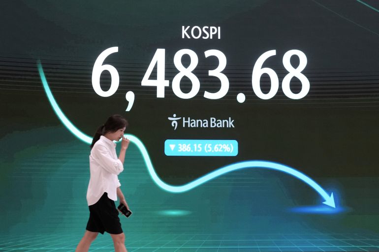 A currency trader passes by a screen showing the Korea Composite Stock Price Index (KOSPI) at the foreign exchange dealing room of the Hana Bank headquarters in Seoul, South Korea, Wednesday, August 19, 2026