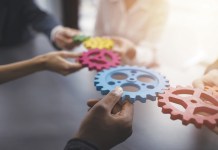 Teamwork of businesspeople work together and combine pieces of gears. Partnership and integration concept
