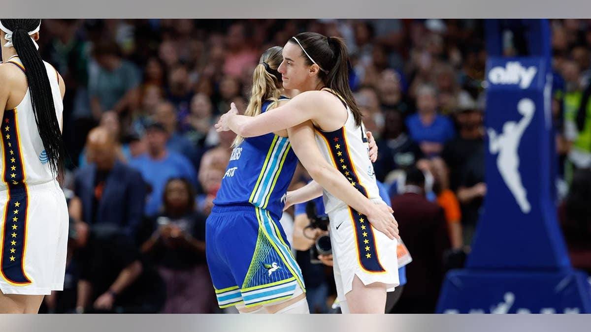 Caitlin Clark and Paige Bueckers greet each other before a WNBA game