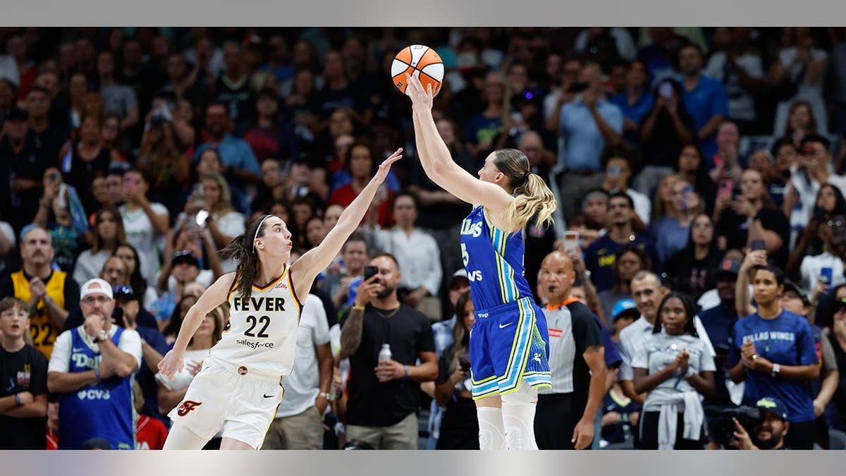 Caitlin Clark plays defense against Paige Bueckers during a WNBA game