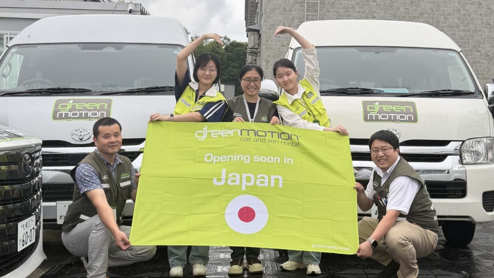 Green Motion team with banner bearing Japanese flag.