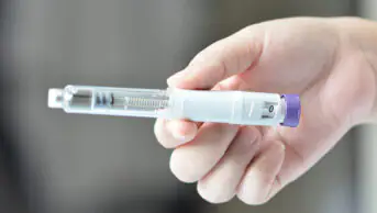 A woman holds a weight-loss pen