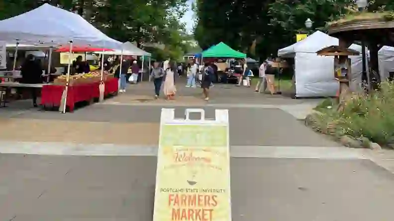 Welcome sign in front of market tents at Portland State University