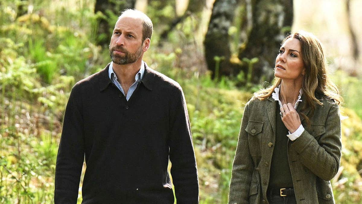 The Prince and Princess of Wales walking together in a forest looking concerned.