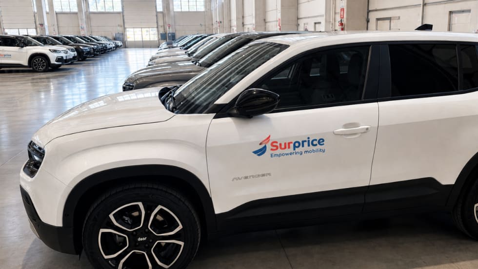 Close up of a row of white CUVs in the Surprice Mobility fleet at the Milan airport.