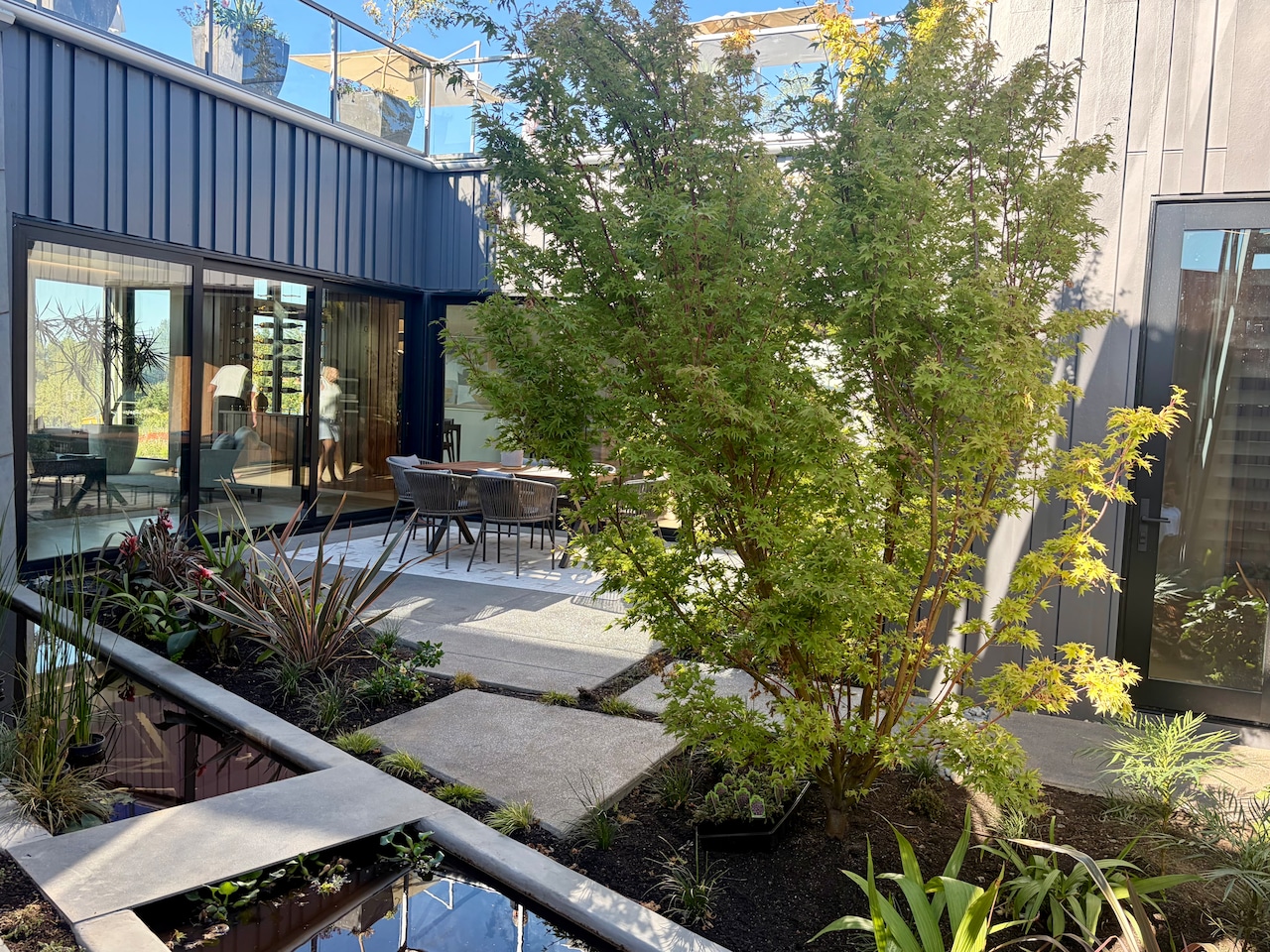 Creekside Homes built a stone-clad dwelling with glass walls facing interior courtyards. At the house called Park Place, the 2,850-square-foot interior extends into a 3,000-square-foot terrace. [terrace is larger than the square footage of the house. Take stairs from the courtyard outside the front door and it feels like a hotel rooftop lounge. 2026 NW Natural Street of Dreams runs July 30-Aug. 23, with people able to tour seven high-end residences in a range of architectural styles at the main venue in the Serres Farms development in Oregon City.