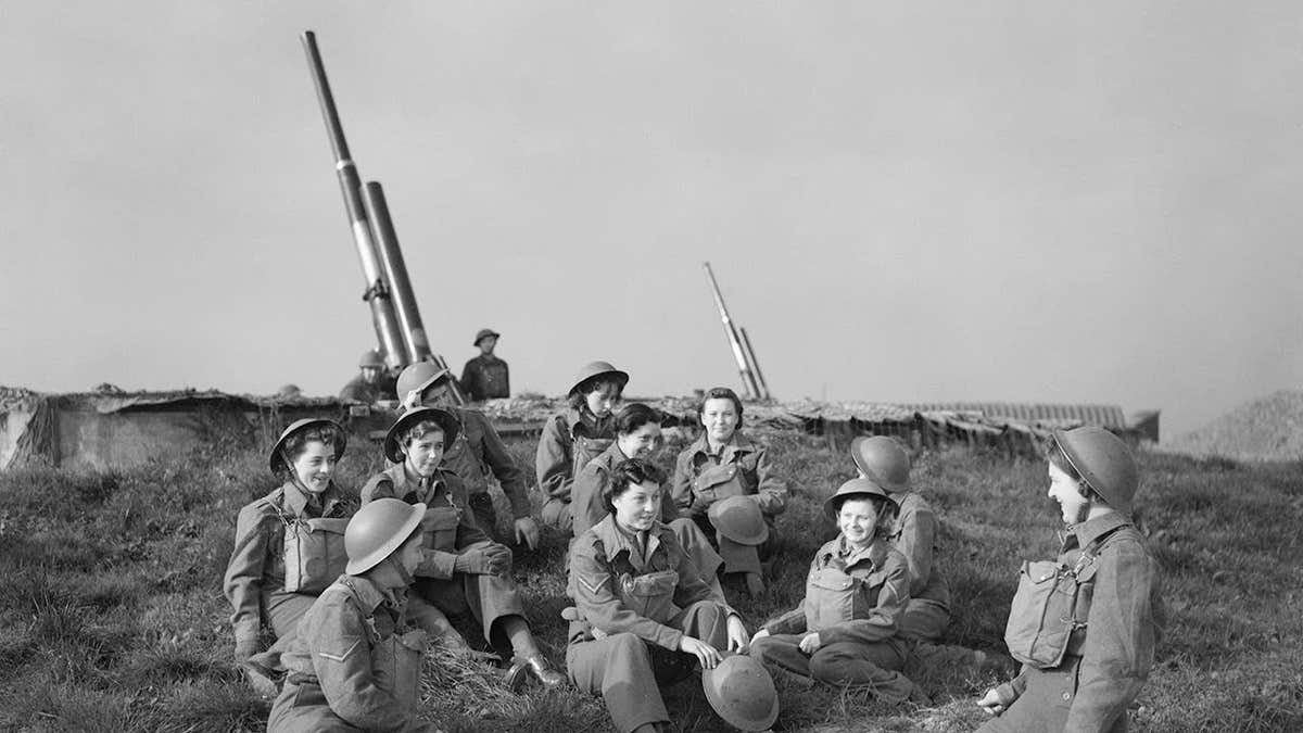 ATS women take a break beside a 3.7-inch anti-aircraft gun at Wormwood Scrubs.