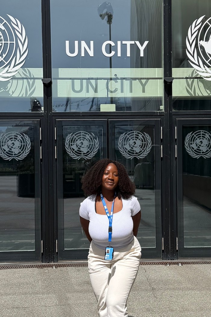 Grace Awuma stands in front of a UN office while posing for a photo.