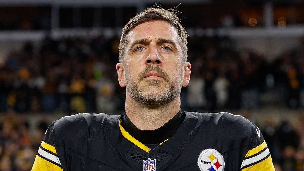 Aaron Rodgers stands for the national anthem at Acrisure Stadium.