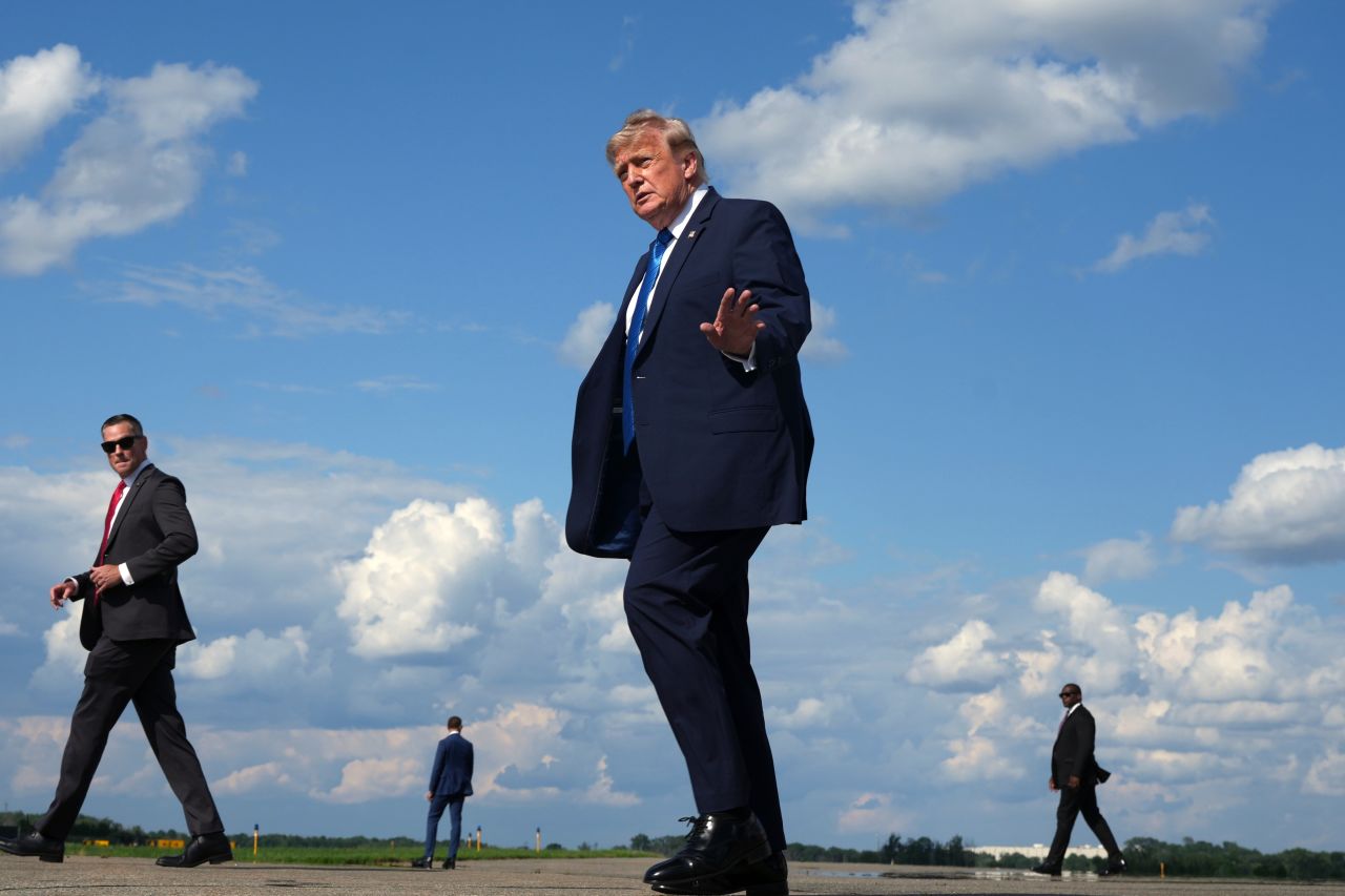 President Donald Trump waves as he walks from Air Force One at Morristown Municipal Airport in Morristown, on Friday.