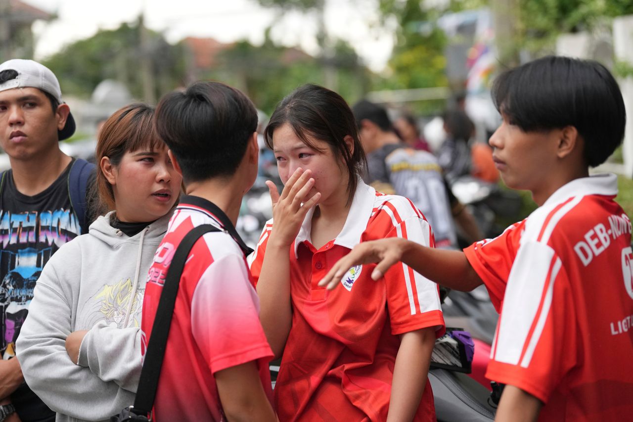 A schoolgirl cries outside her school after the shooting.