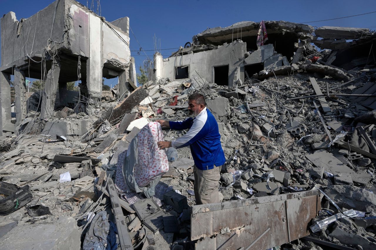 A man removes a mattress from the rubble of a destroyed home that was hit by an Israeli airstrike in Ansar village, southern Lebanon, on Saturday.